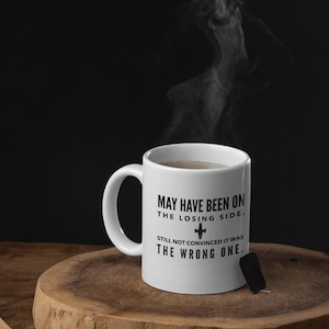 May include: White ceramic mug with a black graphic that reads "May have been on the losing side. Still not convinced it was the wrong one." The graphic also includes a small black and white image of a spaceship.