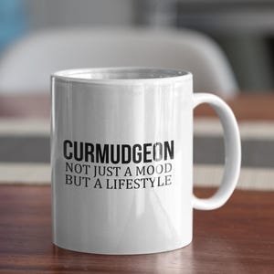 Pode incluir: Caneca de café de cerâmica branca com texto preto que diz "Curmudgeon Not Just A Mood But A Lifestyle".