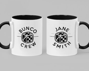 May include: Two white ceramic mugs with black rims and handles. One mug says "Bunco Crew" with a black and white dice graphic. The other mug says "Jane Smith" with a black and white dice graphic.