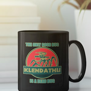 Könnte beinhalten: Schwarze Kaffeetasse mit einer Grafik eines Käfers mit dem Text "Der einzige gute Käfer ist ein toter Käfer" und den Worten "Klendathu" in einem Kreis.