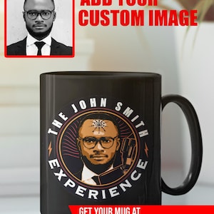 Puede incluir: Taza de cerámica negra con un retrato y el texto "THE JOHN SMITH EXPERIENCE". La taza también tiene el texto rojo "ADD YOUR CUSTOM IMAGE" y "GET YOUR MUG AT CUSTOMATOMIC.COM". Se ve un asa negra.