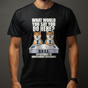 May include: Black t-shirt featuring a white graphic of two Shiba Inu dogs sitting at desks with the text "What would you say you do here?" and "D.O.G.E. Department of Government Efficiency."