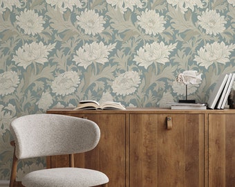 May include: A light blue wallpaper with a floral pattern of white flowers and leaves. The wallpaper is behind a wooden cabinet with a chair in front of it.