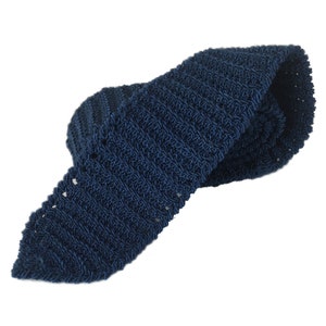 May include: A dark blue knitted tie with a textured pattern. The tie is folded in half and the ends are tucked into the fold.
