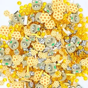 May include: A mix of yellow and brown resin charms featuring honeycomb patterns, bears, and bees. These charms are perfect for adding a touch of whimsy to jewelry, crafts, and other projects.