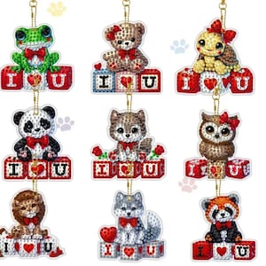 May include: A collection of nine decorative ornaments featuring various animals, including a frog, bear, turtle, panda, wolf, owl, lion, husky, and red panda. Each animal sits atop blocks spelling "I ❤️ U."