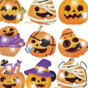 May include: A collection of nine orange Halloween-themed pumpkin designs. Each pumpkin has a unique face and is decorated with elements like a mummy wrap, pirate eye patch, witch hat, and cupcake. The pumpkins are embellished with sparkling accents.