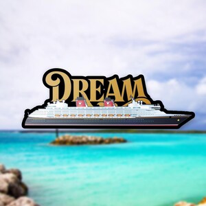 Puede incluir: Una pegatina con un dise&ntilde;o de crucero con la palabra "DREAM" en letras doradas. El barco es blanco con detalles en negro y rojo. El fondo muestra una escena de oc&eacute;ano tropical con agua azul y un cielo nublado.