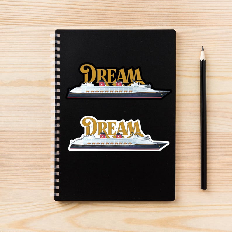 Puede incluir: Dos pegatinas con un dise&ntilde;o de crucero con la palabra "DREAM" en letras doradas. El barco es blanco con un casco negro, chimeneas rojas y detalles azules. Las pegatinas est&aacute;n en un cuaderno negro.
