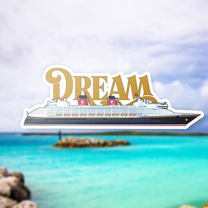 Puede incluir: Una pegatina con un crucero con la palabra "DREAM" en letras doradas. El barco es blanco con detalles en negro y rojo. El fondo es una imagen borrosa de una playa tropical con agua turquesa y un cielo nublado.