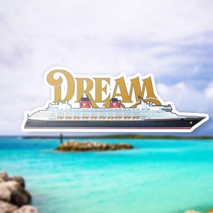 K&ouml;nnte beinhalten: Ein Aufkleber mit einem wei&szlig;en Kreuzfahrtschiff mit roten Akzenten und dem Wort "DREAM" in goldenen Buchstaben. Das Schiff ist vor einem blauen und wei&szlig;en Hintergrund platziert.