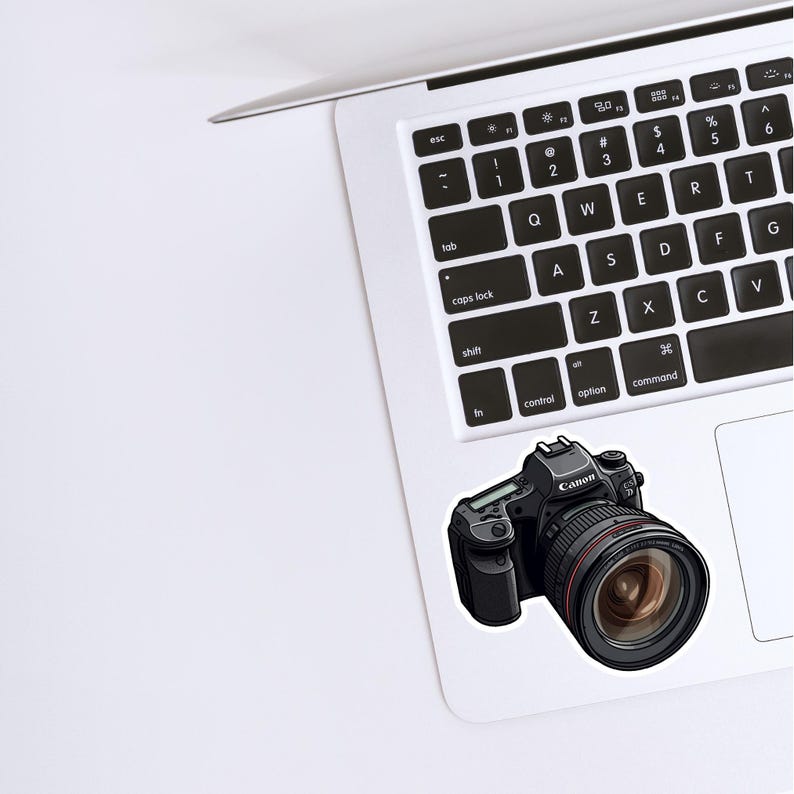 May include: A black Canon DSLR camera with a large lens. The camera has a black body with silver accents and a black lens with a silver ring around the lens.