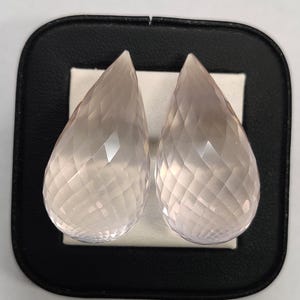 Coppia di gocce di quarzo rosa, 139,50 ct, 35 x 18 mm. Coppia abbinata di pietre preziose briolette sfaccettate a goccia di quarzo rosa per realizzare orecchini e gioielli.