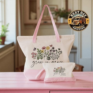A pink tote bag with a floral design and the text " Grow in grace" printed on it, along with a smaller white bag with the same floral design and text. The bags are placed on a pink surface, and there is a logo for "Next Day Shipping" in the background.