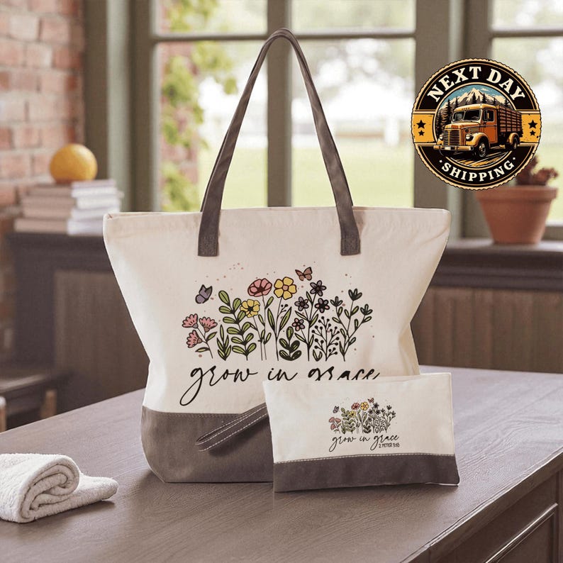 A large tote bag with a floral design and the text "grow in grace" printed on it, placed on a wooden surface. There is also a smaller bag or pouch with the same floral design and text.