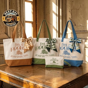 a collection of tote bags and a small bag, all with the same design and text, placed on a wooden surface.