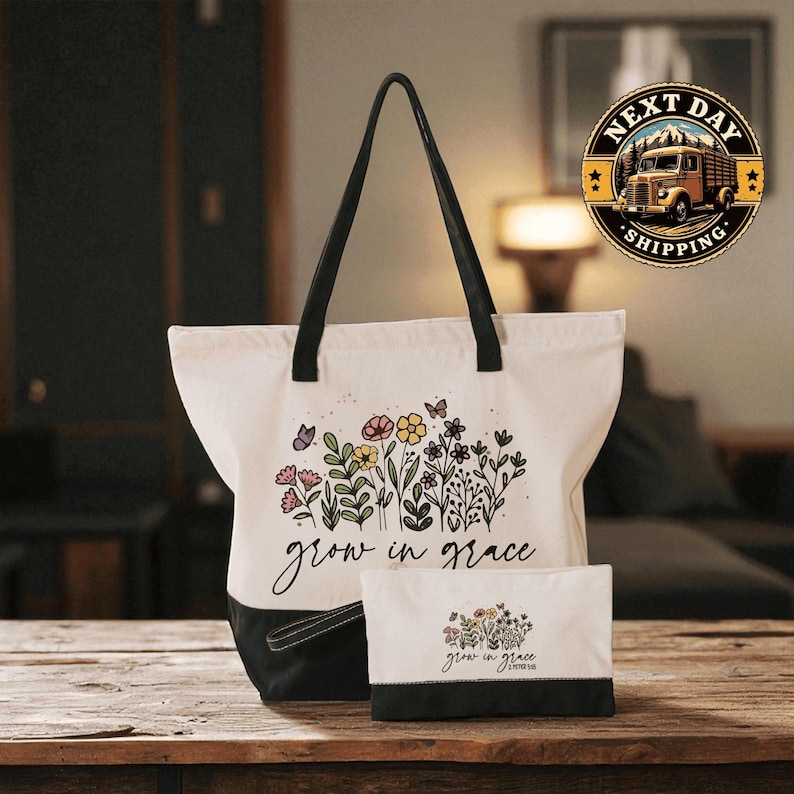 A white tote bag with a floral design and the text " Grow in Grace" printed on it, along with a smaller white bag with a similar floral design and the text " Grow in Grace" printed on it, both placed on a wooden surface.