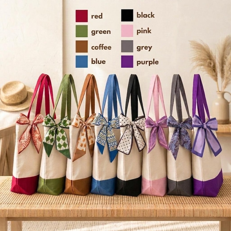 A row of colorful tote bags with bows, each bag displaying a different color and pattern, arranged on a wooden surface.
