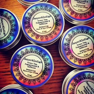 Pu&ograve; includere: Pi&ugrave; contenitori piccoli in argento con etichette colorate che recitano "Jasper&Indigo Green Tea, Pomegranate & Caffeine Awakening Face & Eye Cream 50ml".