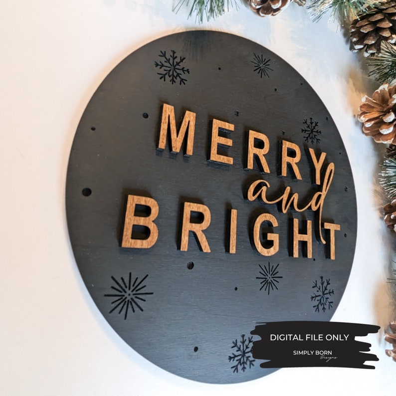 May include: A black circular wooden sign with the words "Merry and Bright" in brown wood letters. The sign is decorated with small black snowflakes.