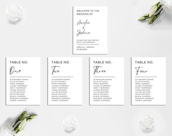 May include: Four white table cards with black text. Each card has a table number, 'One', 'Two', 'Three', and 'Four', and a list of names for each table. The text on the top card reads 'Welcome to the Wedding of Amelia & Joshua'.