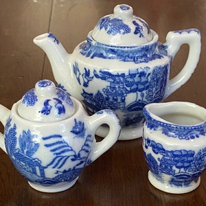 Könnte beinhalten: Ein blaues und weißes Porzellan-Tee-Set mit Teekanne, Milchkännchen und Zuckerdose. Das Set zeigt ein traditionelles chinesisches Design mit einem blauen und weißen Blumenmuster.