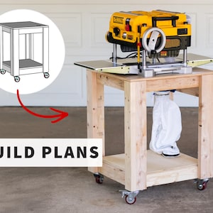 May include: A wooden mobile workbench with four caster wheels, supporting a yellow and black DeWalt thickness planer. A white dust collection bag hangs beneath the top surface. A circular graphic shows a line drawing of the stand with the text BUILD PLANS.