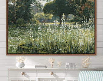 May include: A framed painting depicting a lush green woodland with a clearing filled with white flowers. The flowers are in bloom and the woodland is in the background.