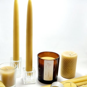 Pu&ograve; includere: Un assortimento di candele in cera d'api di varie forme. Include candele alte e sottili in portacandele di vetro, una candela cilindrica con motivo a nido d'ape e piccole candele votive. &Egrave; presente anche una candela in barattolo con etichetta.