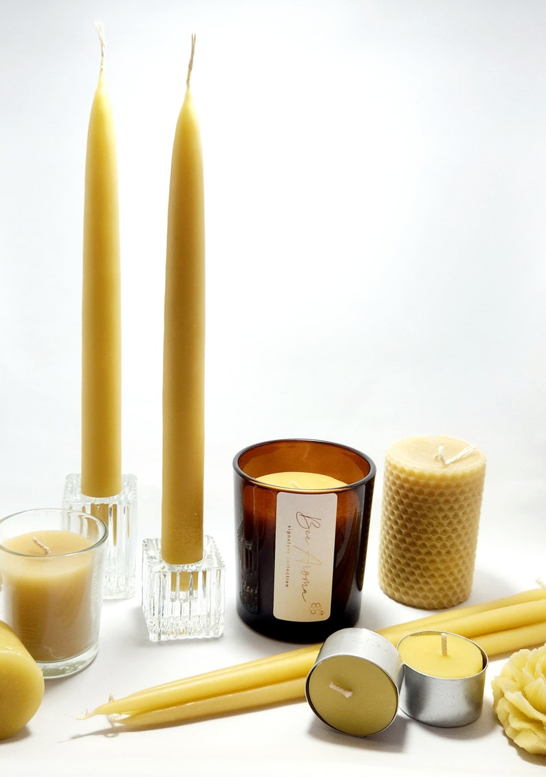 Pu&ograve; includere: Un assortimento di candele in cera d'api di varie forme. Include candele alte e sottili in portacandele di vetro, una candela cilindrica con motivo a nido d'ape e piccole candele votive. &Egrave; presente anche una candela in barattolo con etichetta.