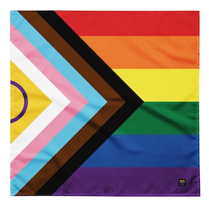 Puede incluir: Una bandera del orgullo con rayas negras, marrones, azul claro, rosas, blancas, amarillas, verdes, azules y moradas. La bandera también presenta un triángulo negro con un triángulo blanco más pequeño en su interior, y un triángulo amarillo con un círculo morado en su interior.