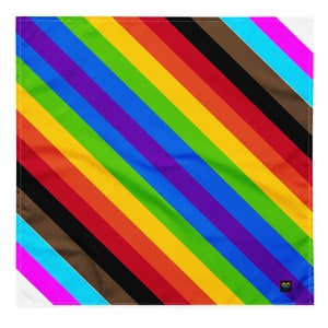 May include: A diagonal rainbow pride flag with black, brown, light blue, and pink stripes. The flag is made of fabric and has a slightly textured surface.
