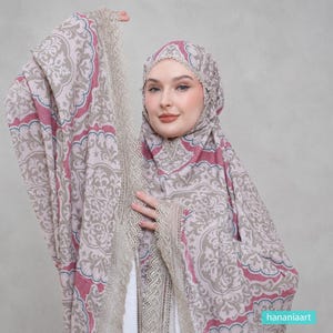 May include: A prayer garment featuring a light beige and dusty rose damask pattern with intricate lace trim along the edges. The head covering and matching wrap display a repeating floral motif in muted tones, accented by delicate scalloped lace.