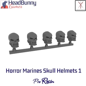 Puede incluir: Una fila de cinco cascos de calavera grises, cada uno con rasgos faciales detallados y una sonrisa amenazante. Los cascos están montados en una barra gris. El texto "Horror Marines Skull Helmets 1" y "Pro Resin" se muestra debajo.