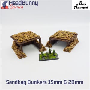 Op de afbeelding: Twee miniatuur zandzakbunkers gemaakt van beige getextureerde zandzakken en bruine houten steunbalken. Een kleine rechthoekige basis bevat vier groene miniatuursoldaten die op een stuk groen gras en grijs rotsachtig terrein staan.