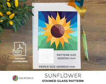 May include: A stained glass pattern of a sunflower with numbered sections. The pattern is printed on a white sheet of paper with the text "PATTERN SIZE 500X500 mm" and "PAPER SIZE 600X600 mm". The text "SUNFLOWER STAINED GLASS PATTERN" is printed below the pattern.