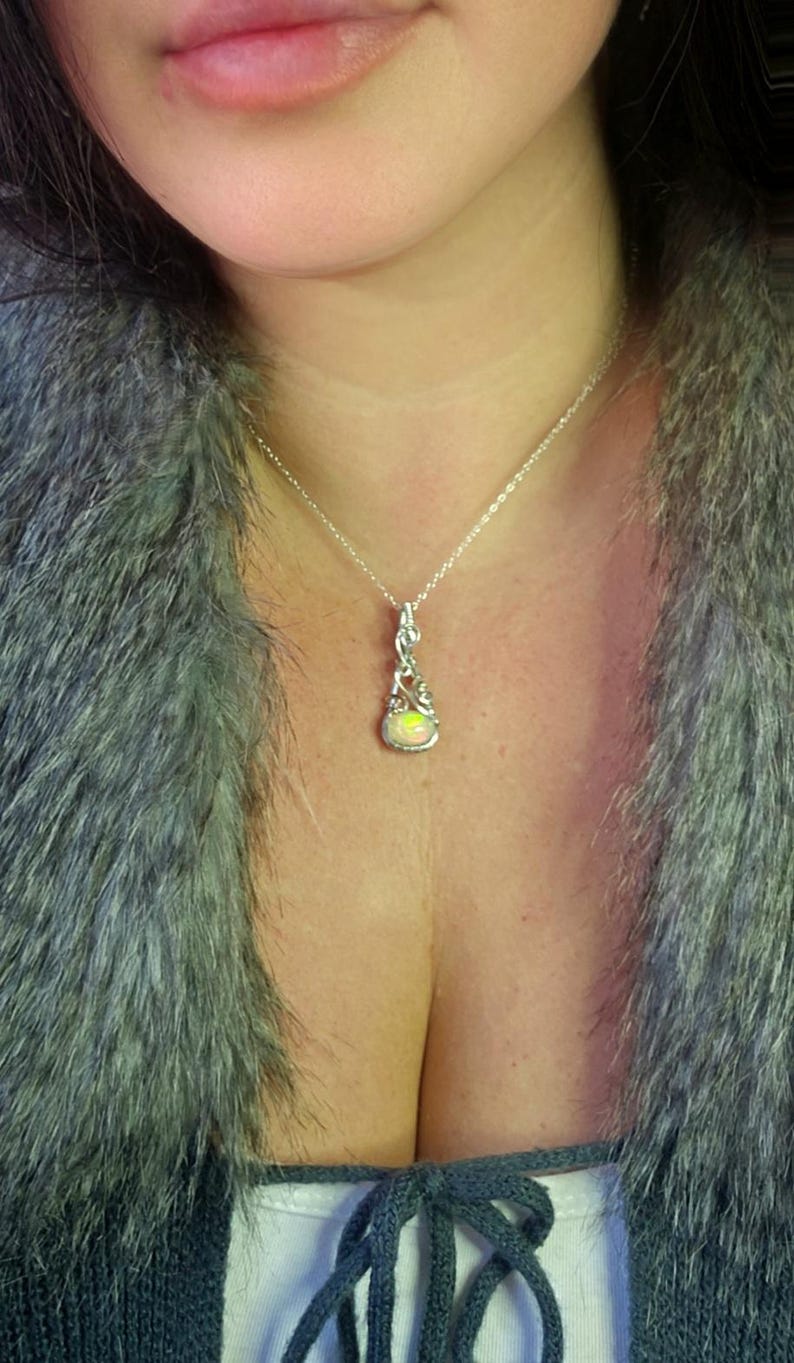 2.3 carat Ethiopian Fire Opal wire wrapped in luxurious 940 Argentium Silver, known for its superior brightness and tarnish resistance, into a high-end gemstone pendant necklace that exudes a whimsical earthy charm reminiscent of vintage treasures.
