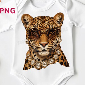 May include: White baby bodysuit featuring a leopard illustration wearing sunglasses and a jeweled necklace. The leopard has a brown and black spotted coat. The sunglasses are brown with a gold frame. The necklace and earrings have large, clear jewels.