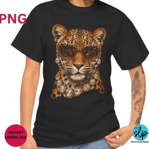 May include: Black t-shirt featuring a leopard wearing sunglasses and a diamond necklace. The leopard has a spotted pattern in shades of brown and tan. The sunglasses are brown. The shirt is a crew neck style.