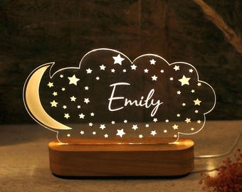 May include: A wooden night light shaped like a cloud with stars and a crescent moon. The name "Emily" is written in the center of the cloud.