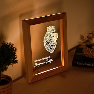 Può includere: Un cartello luminoso con cornice in legno con un design a cuore geometrico e il testo "Cardiology Specialist" e "Benjamin Button".