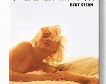 May include: A book cover titled "THE LAST SITTING" by Bert Stern. The cover features a photograph of a woman with blonde hair lying on a bed. The image has a warm, golden color palette.