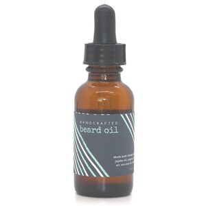 May include: A brown glass bottle with a black dropper top and a label that says "HANDCRAFTED beard oil". The label has a striped design in white and green.
