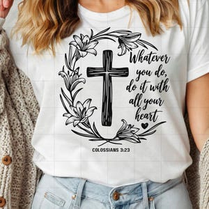 May include: White t-shirt with a black and white graphic design featuring a cross surrounded by flowers. The text "Whatever you do, do it with all your heart" is written below the cross. The text "Colossians 3:23" is written below the text.