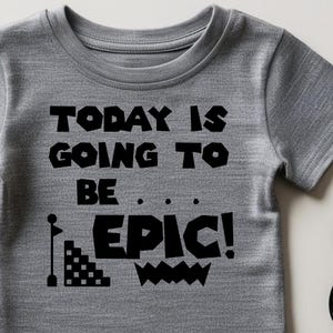 May include: Gray short-sleeved t-shirt with black text that reads "Today is going to be... EPIC!" with a graphic of a flag and a block tower.