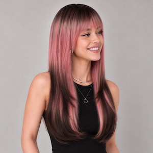 Puede incluir: Una peluca larga y lisa con un corte a capas y flequillo. El color del cabello es una mezcla de raíces de color marrón oscuro que se transforman en reflejos de color rosa vibrante a lo largo, creando un aspecto multitonal con textura lisa.