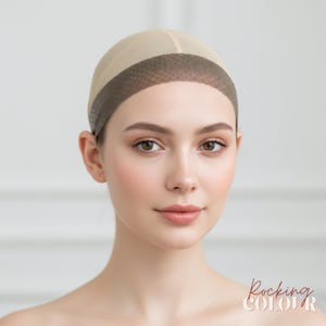 Puede incluir: Una gorra de peluca beige con una banda marrón oscuro alrededor de la frente. La gorra se usa en la cabeza de una persona. El texto "Rocking COLOR" está en la esquina inferior derecha.