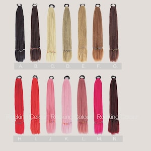 May include: Assortment of 14 hair extensions in various colors, including black, brown, blonde, red, pink, and maroon. Each extension is tied with a black elastic band and has beads at the bottom. The extensions are labeled with letters A through N.