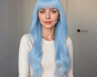 May include: A woman wearing a long, light blue wig with bangs. The wig has long, wavy hair. She is wearing a white long-sleeved shirt. The background is a neutral color.