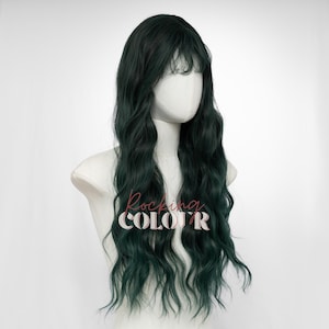 May include: A dark green wig with long, wavy hair and bangs, displayed on a mannequin head. The wig has a natural-looking style and is designed to be worn. The text "Rocking COLOR" is visible on the front of the mannequin.